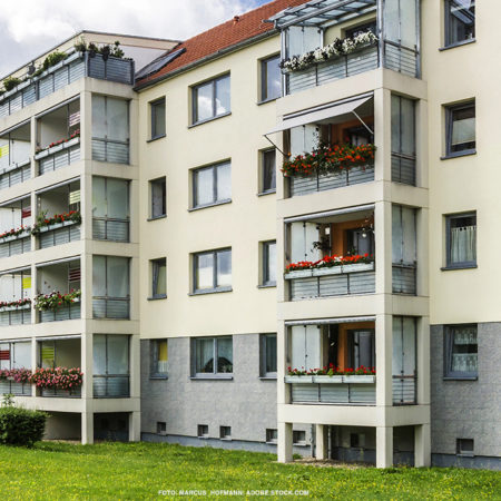 Ansicht von Wohnungsblock mit cremefarbener Wand und vielen Balkonen